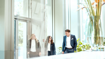 Three people walking in the Building